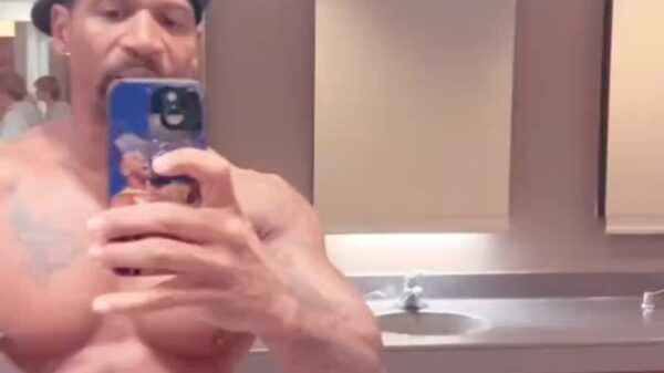 A shirtless Stevie J flexes in a public men's restroom while reacting to Diddy's son, King Combs, 50 cent diss song "Pick a Side."