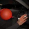 Man puffs a balloon while driving