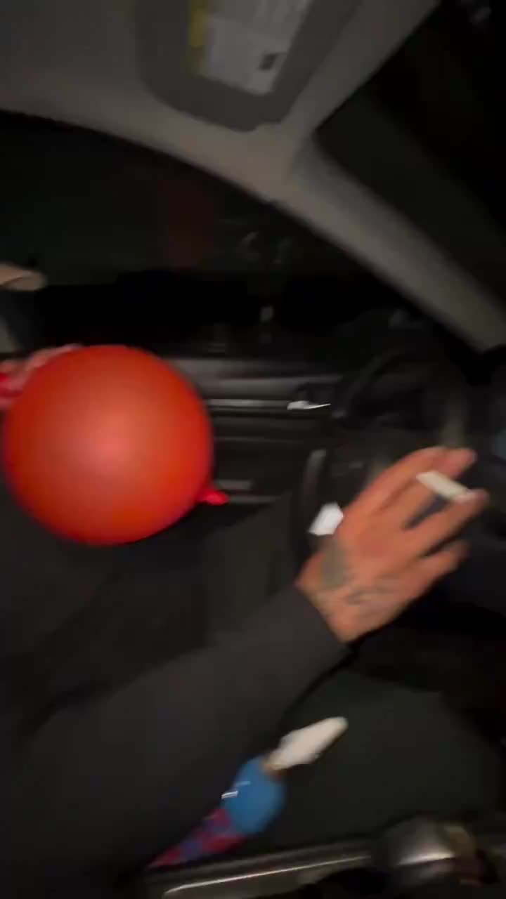 Man puffs a balloon while driving