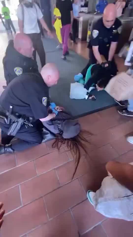 Police deploy full force to arrest two teenage girls for jumping a BART train gate in Oakland, California