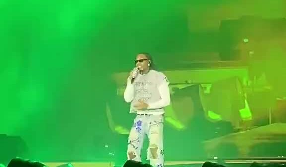 Gunna performs with a fan after he ran onto the stage