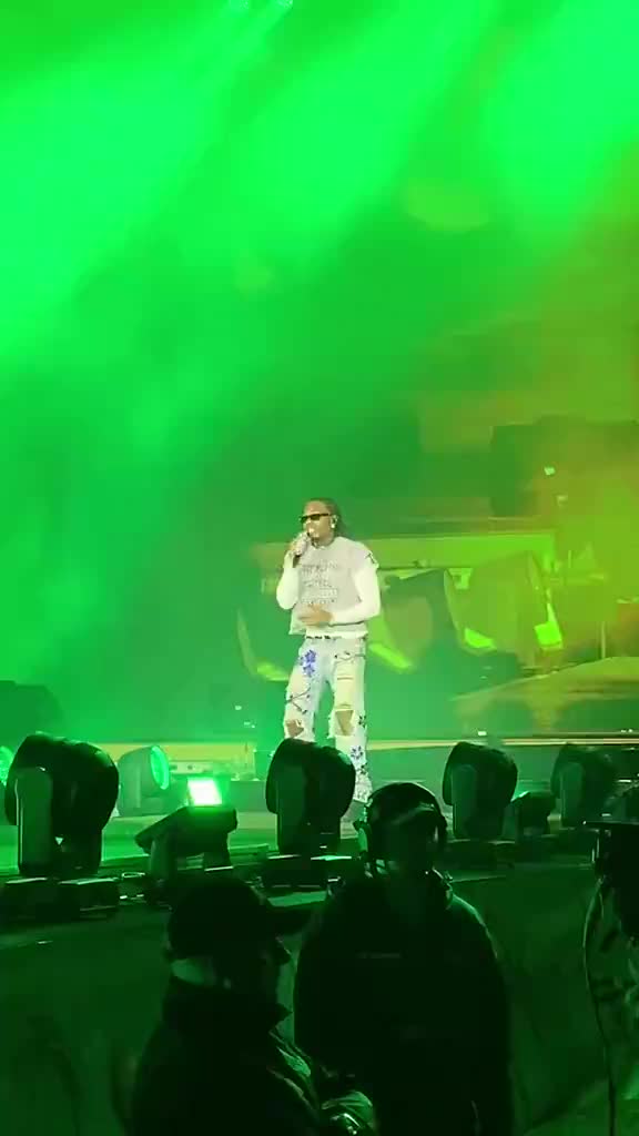 Gunna performs with a fan after he ran onto the stage