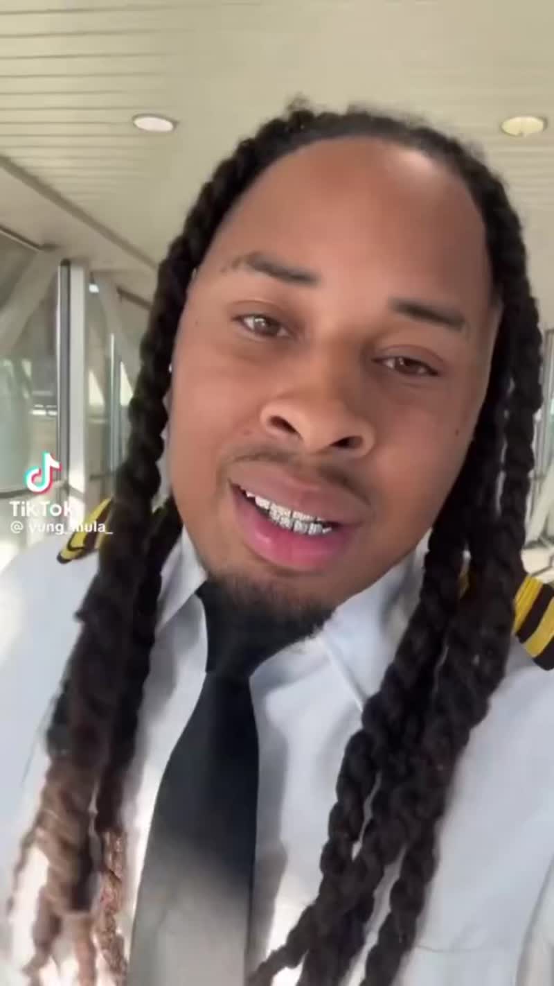 A Black pilot is facing backlash after sharing a video of himself with dreadlocks and grills following a flight.